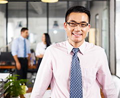 man with glasses and tie in office