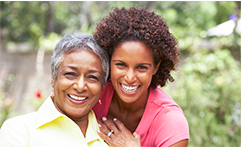 mother and daughter sitting outside smiling