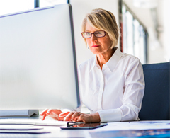 woman with glasses sitting using computer