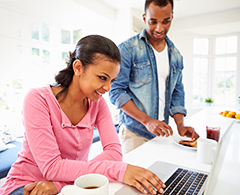 couple sitting at counter using computer