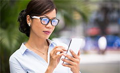 woman with glasses outside using phone