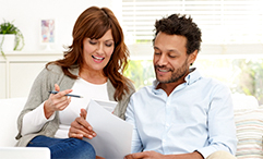 couple sitting on couch doing paperwork