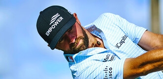 Golfer Cam Young swinging golf club wearing Empower hat