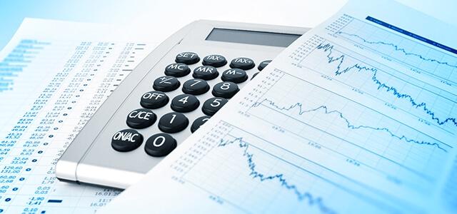 Financial charts sit atop a calculator