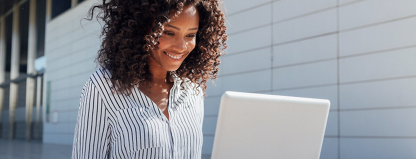 A financial professional reads research paper on her laptop