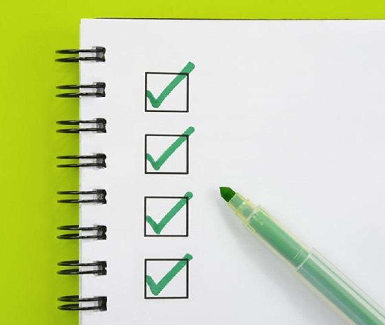 Notebook with green checkboxes and marker