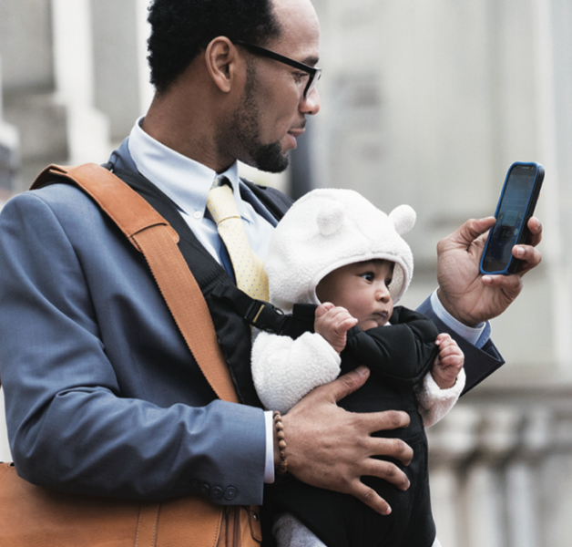 Man on cellphone wearing a baby