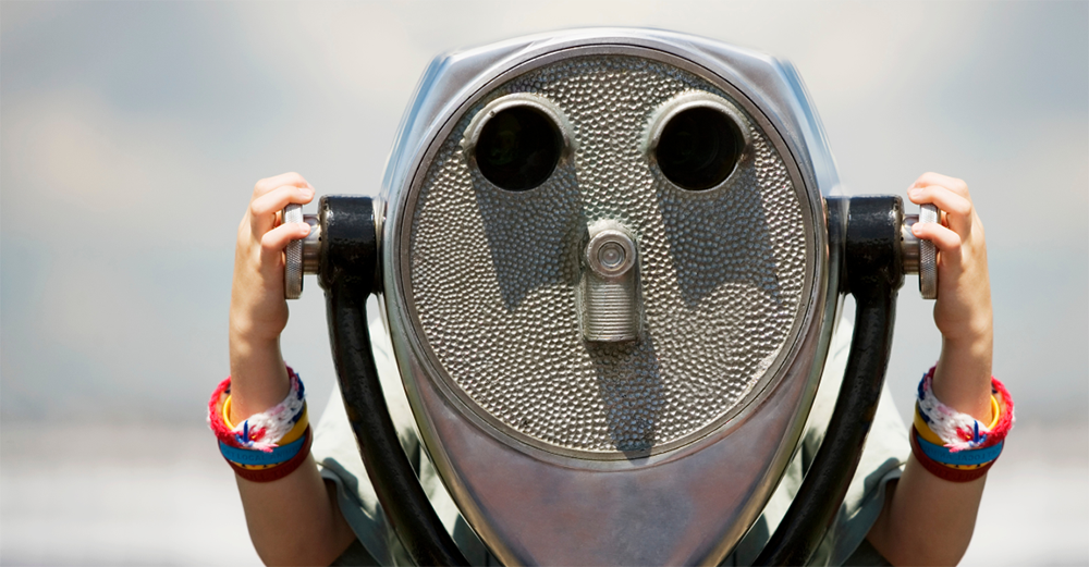 A person looks through a long range binocular
