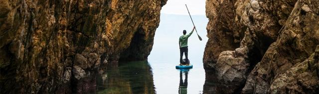 Man standing on kayak in water