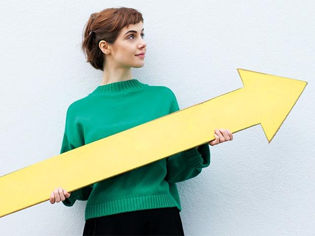 Woman holding arrow. top 5 financial goals for 2021