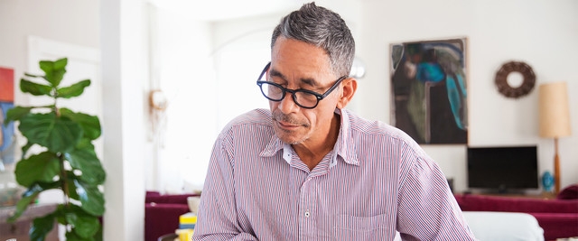 man sitting at desk, reviewing finances