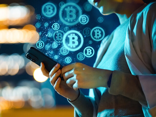 Image of a mobile phone user with bitcoin logos