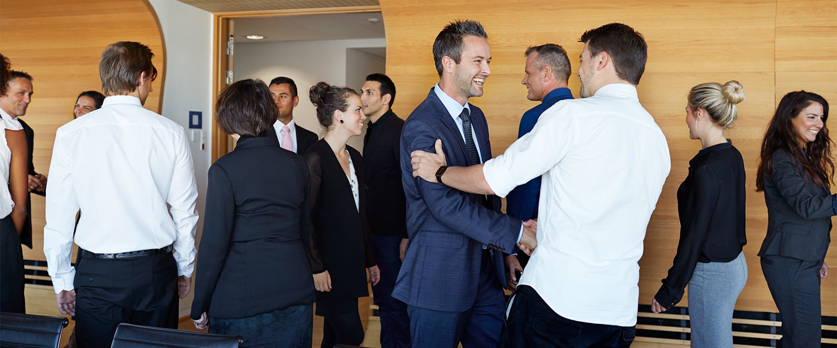 A group of employees shaking hands and welcoming each other